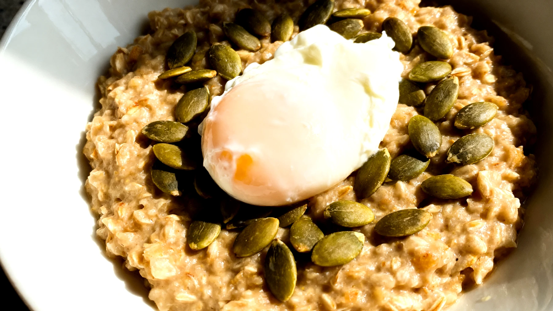 Porridge salato con avena integrale, semi di zucca e uovo in camicia"